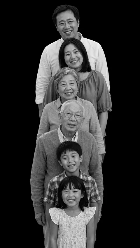 Three generations of a family of six in a stacked monochrome studio portrait, from the tallest adult at the back down to the youngest child at the front